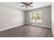 A well-lit bedroom with hardwood floors and a large window overlooking the yard at 4030 Se 134Th St, Belleview, FL 34420