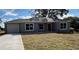 Newly constructed home with gray exterior, driveway, and grassy lawn at 4030 Se 134Th St, Belleview, FL 34420