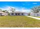 Single story home with gray exterior, well-manicured lawn, concrete driveway, and a one-car garage at 4030 Se 134Th St, Belleview, FL 34420