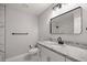 Modern bathroom with granite countertop, black matte faucet, and a large mirror at 5761 Ne 4Th Pl, Ocala, FL 34470