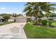 Charming single-story home with a well-manicured lawn, mature palm tree, and a two-car garage in a suburban setting at 16369 Sw 14Th Avenue Rd, Ocala, FL 34473