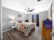 Bright bedroom featuring a bed with floral pattern, a ceiling fan, and a dresser with a decorative table runner at 1934 Nw 79Th Loop, Ocala, FL 34475