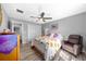Comfortable bedroom with a ceiling fan, and a cozy chair, featuring a beautiful bed with decorative pillows at 1934 Nw 79Th Loop, Ocala, FL 34475