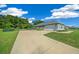 Charming home exterior with a well-manicured lawn and long driveway leading to a two-car garage at 1934 Nw 79Th Loop, Ocala, FL 34475