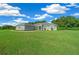 Inviting single-Gathering home with a lush green lawn, complemented by a light gray exterior under a partly cloudy sky at 1934 Nw 79Th Loop, Ocala, FL 34475