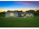 Charming single-story home with a well-manicured lawn, colorful foliage, and a peaceful sunset backdrop at 1934 Nw 79Th Loop, Ocala, FL 34475