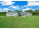 Attractive single-story home featuring a lush green lawn and vibrant landscaping under a bright, sunny sky at 1934 Nw 79Th Loop, Ocala, FL 34475