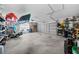 Spacious garage with high ceilings and ample storage, featuring overhead storage racks and workbench at 1934 Nw 79Th Loop, Ocala, FL 34475