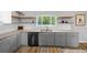 Modern kitchen featuring a stainless steel dishwasher, custom cabinets, stylish decor, and granite counters at 1934 Nw 79Th Loop, Ocala, FL 34475