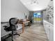Well-lit home office featuring a large window with a view, multiple workstations, and custom shelving for storage at 1934 Nw 79Th Loop, Ocala, FL 34475