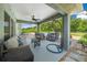 Relaxing covered patio with comfortable seating and a hanging chair, overlooking the expansive backyard at 1934 Nw 79Th Loop, Ocala, FL 34475