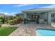 Covered patio with seating and pool view, enhanced by a lush, well-manicured garden area at 1934 Nw 79Th Loop, Ocala, FL 34475