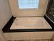 Close-up of a white soaking bathtub with black countertop in a bright bathroom at 3174 Sw 189Th Ave, Dunnellon, FL 34432