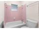 Bathroom with pink tile, shower, and bathtub at 1000 Se 155Th St, Summerfield, FL 34491