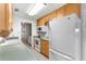 Galley kitchen with wood cabinets, appliances, and access to backyard at 1000 Se 155Th St, Summerfield, FL 34491
