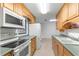 Open kitchen with wood cabinets, appliances, and double sink at 1000 Se 155Th St, Summerfield, FL 34491