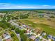 Aerial view of a neighborhood next to a green golf course with ponds and mature trees at 17808 Se 115Th Ct, Summerfield, FL 34491