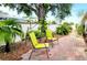 Charming backyard features a brick patio with 2 chairs and lush tropical landscaping, creating a peaceful oasis at 17808 Se 115Th Ct, Summerfield, FL 34491