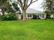 Spacious backyard featuring a well-manicured lawn, mature landscaping, and trees at 17808 Se 115Th Ct, Summerfield, FL 34491