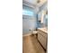 Cozy bathroom with tan tile, vanity, and woven storage cabinet above toilet at 17808 Se 115Th Ct, Summerfield, FL 34491