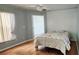 This bedroom offers hardwood floors, light paint, ceiling fan, and a door leading to another room at 17808 Se 115Th Ct, Summerfield, FL 34491