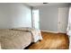 This bedroom features hardwood floors, light paint, and a door leading to the bathroom at 17808 Se 115Th Ct, Summerfield, FL 34491