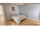 Cozy bedroom with a comfortable bed, hardwood floors, and natural light streaming through the windows at 17808 Se 115Th Ct, Summerfield, FL 34491