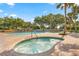 Relaxing community pool area with a jacuzzi surrounded by lush landscaping and comfortable seating at 17808 Se 115Th Ct, Summerfield, FL 34491