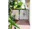 Charming courtyard gate entrance surrounded by lush, tropical foliage and a brick pathway at 17808 Se 115Th Ct, Summerfield, FL 34491