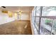 Bright living room boasts large windows with backyard views, tile flooring, and a ceiling fan at 17808 Se 115Th Ct, Summerfield, FL 34491