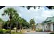 View of the community pool area with yellow umbrellas, mature trees, and clubhouse in the background at 17808 Se 115Th Ct, Summerfield, FL 34491
