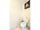 Simple powder room features a toilet with white tile flooring and a sailboat decoration at 5650 Se 34Th St, Ocala, FL 34480