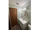 A bathroom with a single sink vanity, mirror with lights, and towel racks nearby at 5877 Nw 64Th St, Ocala, FL 34482