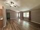 Spacious living room featuring wood flooring, a ceiling fan, and ample natural light at 5877 Nw 64Th St, Ocala, FL 34482