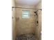 Shower with tiled walls, pebble flooring, and a shower head with a window for natural light at 5877 Nw 64Th St, Ocala, FL 34482