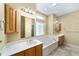 Bright bathroom with double sinks, vanity, a soaking tub, and a decorative window at 11017 Sw 71St Cir, Ocala, FL 34476