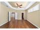 Bright bedroom with tray ceilings, hardwood floors, plantation shutters, and an open doorway at 11017 Sw 71St Cir, Ocala, FL 34476