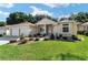 Charming single-story home boasts a meticulously landscaped yard with lush lawn and colorful shrubs at 11017 Sw 71St Cir, Ocala, FL 34476