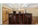 Open kitchen with wooden cabinets, center island, granite countertops, and modern lighting fixture at 11017 Sw 71St Cir, Ocala, FL 34476