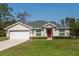 Charming single-story home featuring a well-manicured lawn and a red front door at 4519 Sw 111Th Pl, Ocala, FL 34476