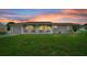 Charming single-story home with a well-manicured lawn and welcoming front porch at sunset at 10820 Sw 87Th Ter, Ocala, FL 34481