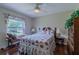 Comfortable bedroom with hardwood floors, a ceiling fan, a large window, and furniture at 15268 Sw 14Th Avenue Rd, Ocala, FL 34473