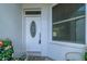 A decorative white front door with oval glass, situated by a window with blinds at 15268 Sw 14Th Avenue Rd, Ocala, FL 34473