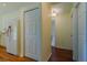 Hallway with wood floors, white cabinets, and an entrance into a room with bright lighting at 15268 Sw 14Th Avenue Rd, Ocala, FL 34473