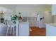Modern kitchen featuring white cabinets, a bar area, stainless steel sink, and connection to a bright, open living space at 15268 Sw 14Th Avenue Rd, Ocala, FL 34473