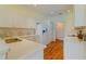 Modern kitchen with white cabinets, sleek countertops, stainless steel sink, and a view into a bright hallway at 15268 Sw 14Th Avenue Rd, Ocala, FL 34473