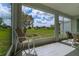 Outdoor seating in a screened lanai features a view of the lush backyard and community green space at 15268 Sw 14Th Avenue Rd, Ocala, FL 34473