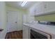 A bright laundry room features modern washer and dryer units, white storage cabinets, and wood flooring at 15268 Sw 14Th Avenue Rd, Ocala, FL 34473