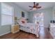 A well lit primary bedroom has wood floors, a decorative ceiling fan, and access to the lanai at 15268 Sw 14Th Avenue Rd, Ocala, FL 34473