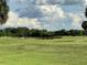 Scenic view of a lush green golf course with a pond at 2733 Scarborough Dr, Kissimmee, FL 34744